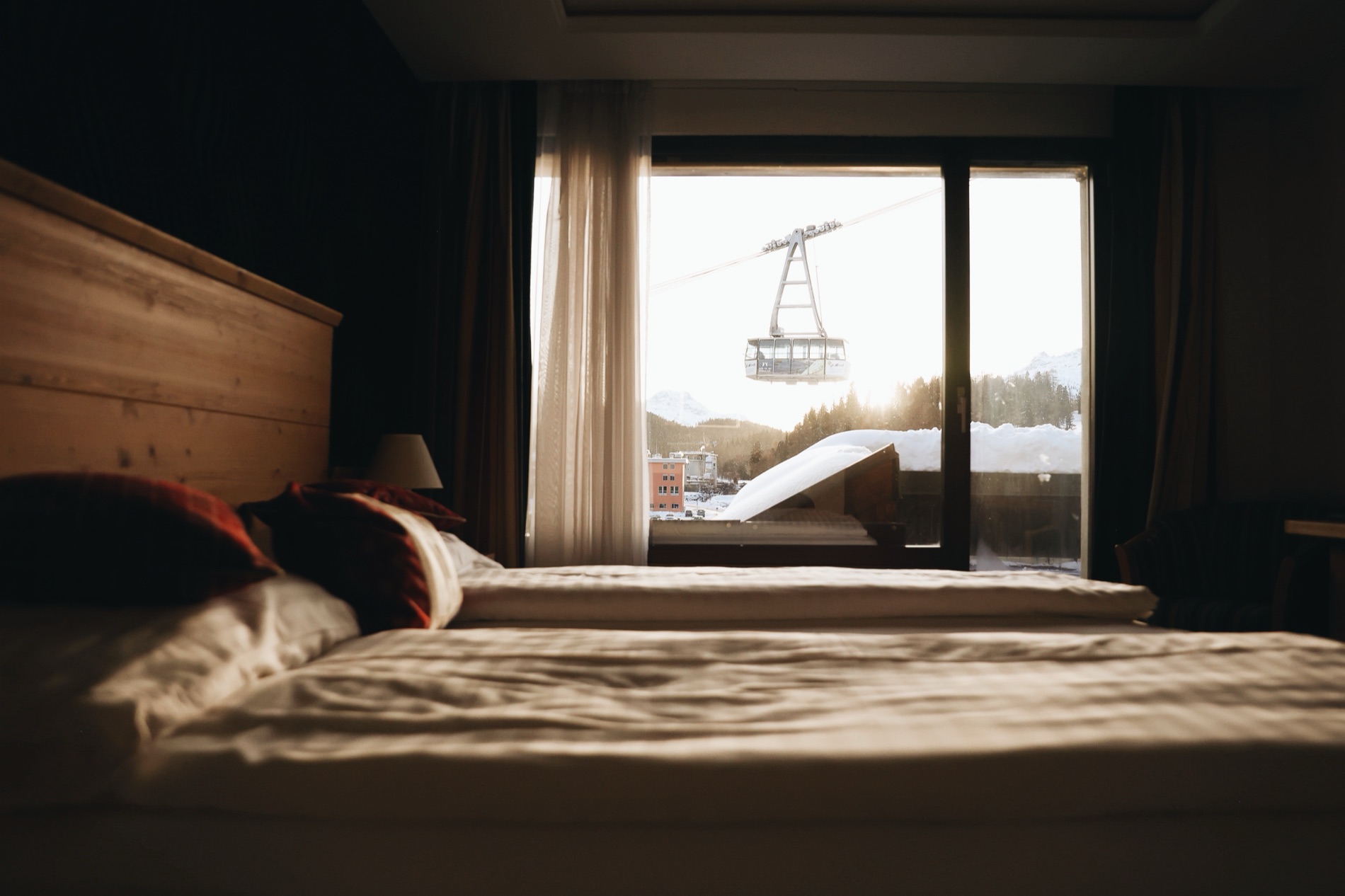 A hotel room at golden hour with a cable car passing the window.